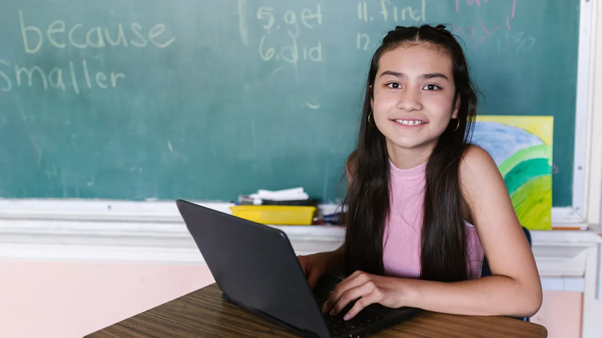 schoolgirl using a laptop in a classroom