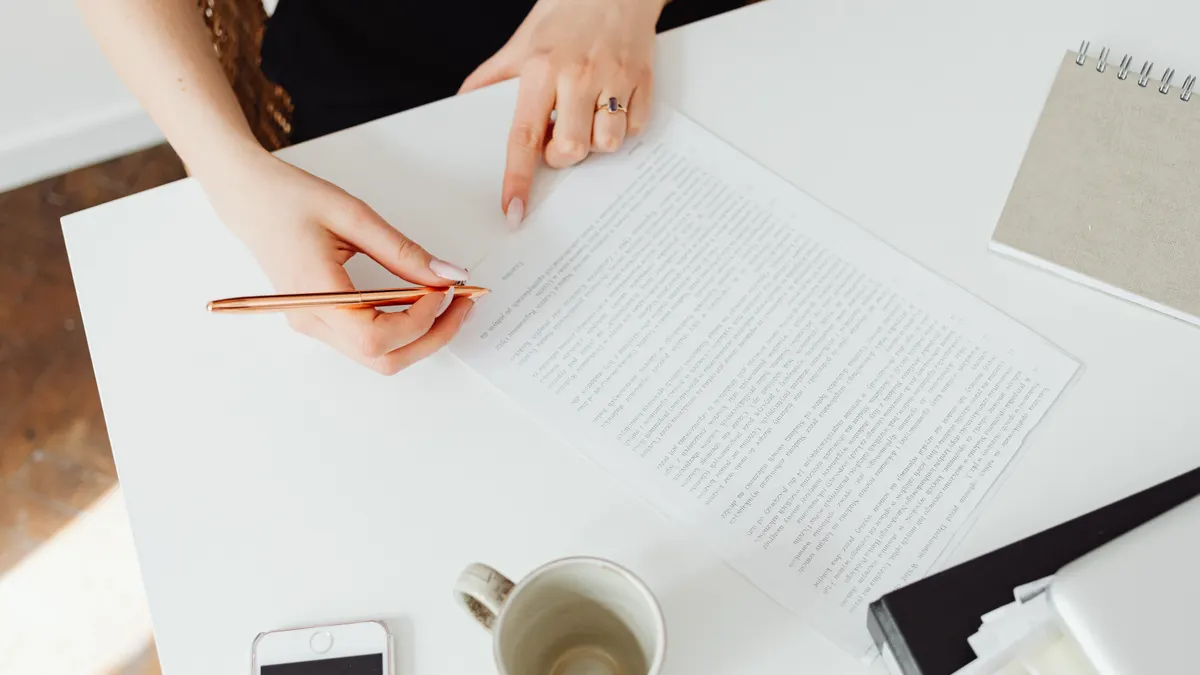 Claude review for content writing — High-Angle Shot of a Person Writing on the Paper Using a Pen