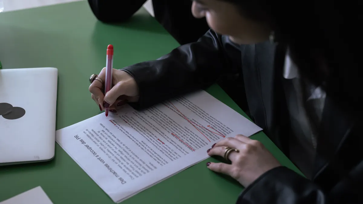 Claude review for content writing — A Person in Black Long Sleeve Shirt Writing on White Paper