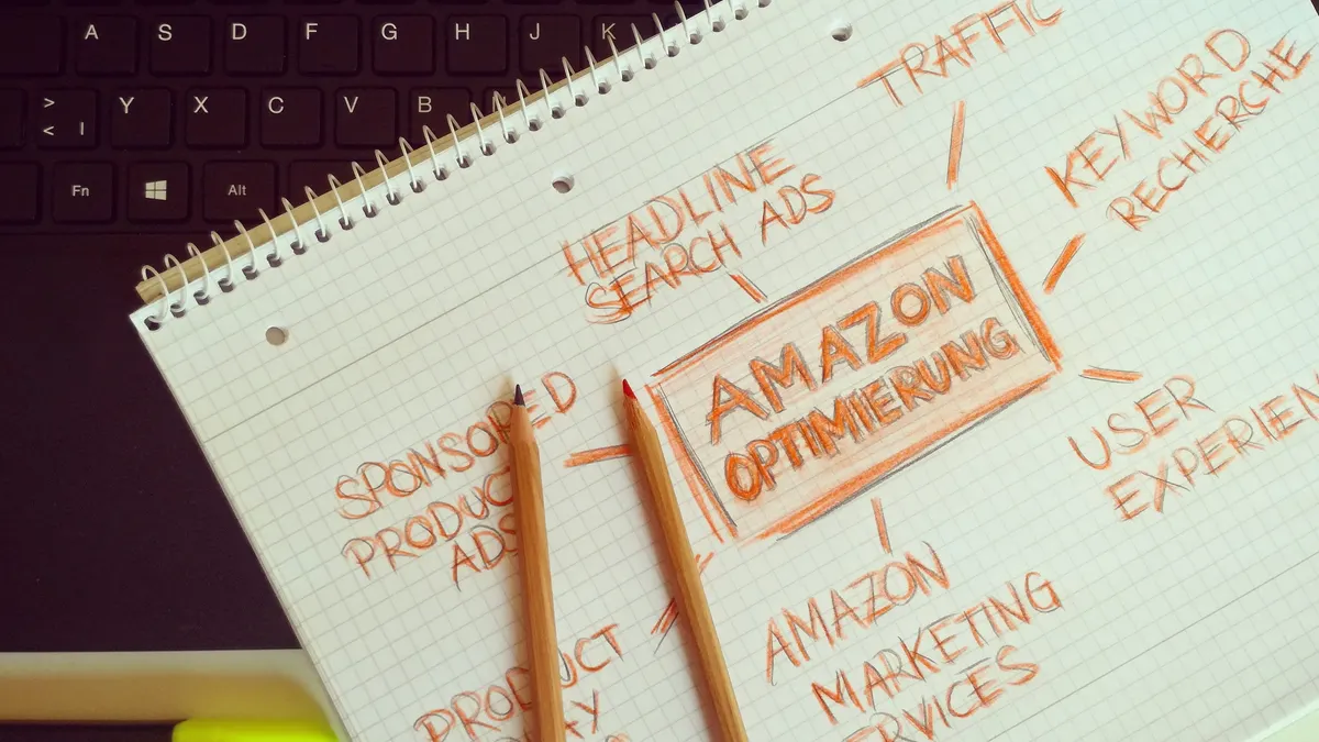Notebook of marketing keyword ideas beside a keyboard