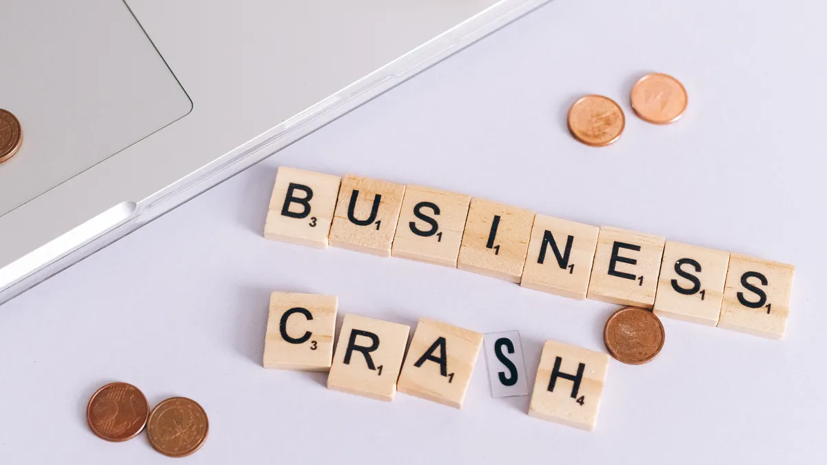 Rytr vs Copy.ai for small businesses — Coins Scattered around a Sign Saying "Small Business Crash" Lying on a Laptop and